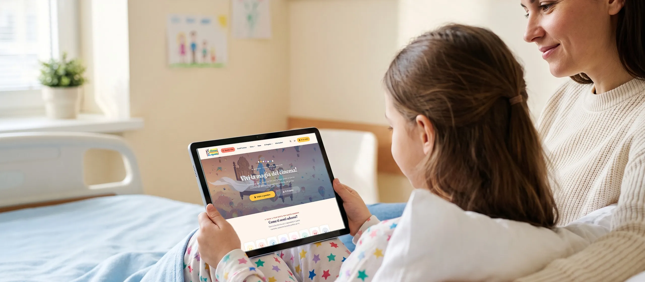 Una bambina in ospedale guarda Cinema in Ospedale su un tablet insieme alla mamma; immagine di scena generata con AI, sullo schermo il sito vero